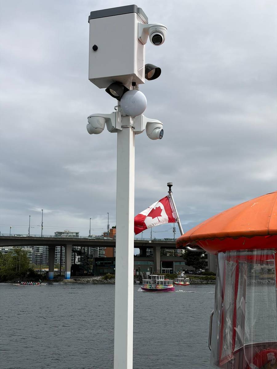 Camera pole on a False Creek dock with the Vancouver skyline behind