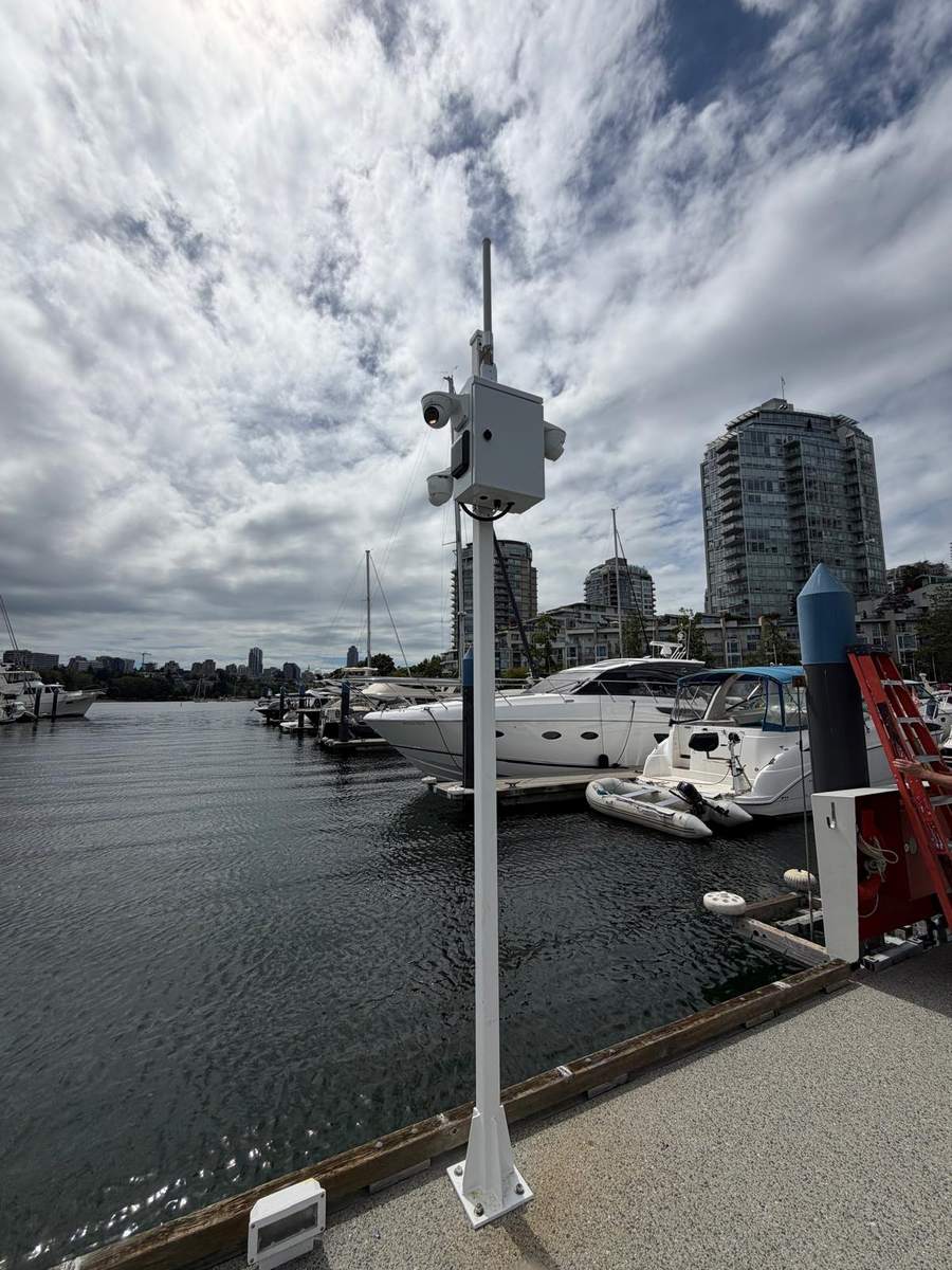 Camera pole installed on a marina dock under an overcast Vancouver sky
